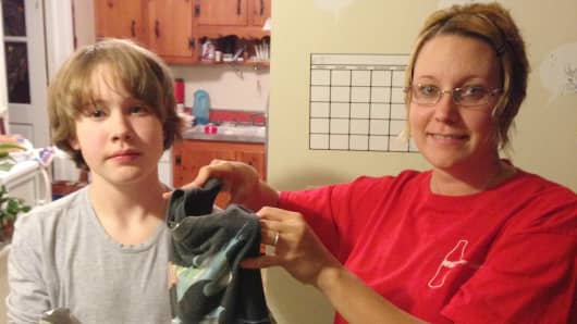 Rachel Farmer and her son, Christopher, bag up some clothing to send to Schoola Stitch. They hope to raise money for his school in Bowling Green, Va.