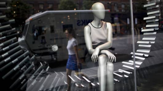 A shopper walks past a store window display in New York.