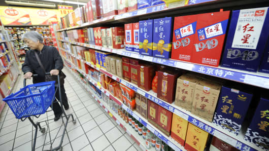 A woman browses bottles of baijiu displayed at a store in Beijing.