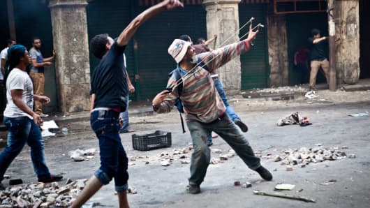 Supporters of ousted president Mohamed Morsi throw stones as they clash with security officers in Cairo's Ramses Square on Friday.