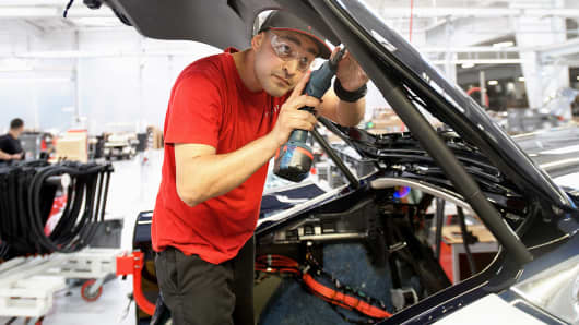 Tesla employee works on a Tesla Model S sedan