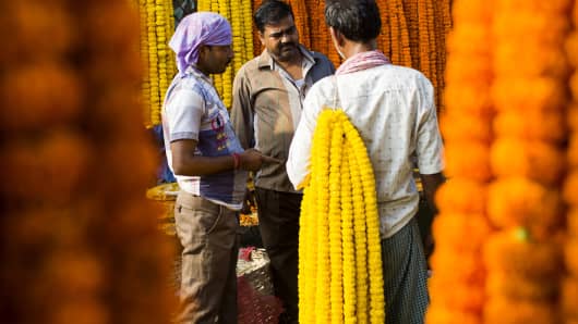 An Indian vendor speaks with a customer at a flower market in New Delhi in August.