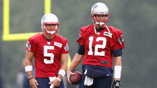 Tom Brady #12 and Tim Tebow #5 look on during the first day of New England Patriots training camp at Gillette Stadium in Foxboro, Mass.
