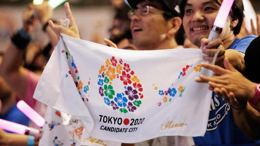 Residents of Olympic bid city Tokyo celebrate while holding Tokyo signs after the announcement of the 2020 Summer Olympic Games host city at Komazawa Olympic Park in Tokyo, Japan.
