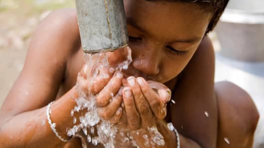 A child drinks water from a WASA run tube well, at a slum in Rayer Bazaar, in Dhaka, Bangladesh.