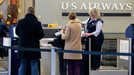 Travelers check in at the US Airways ticket counter at the Pittsburgh International Airport.
