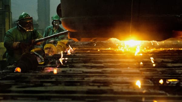 Molten steel is poured into molds for railraod car suspension parts at the Columbus Castings foundry in Columbus, Ohio.