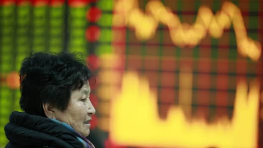 A woman sits at a securities exchange in Huaibei, central China's Anhui province.