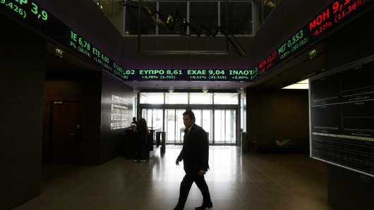 Stock Exchange displays show stock price movements in Athens, Greece.