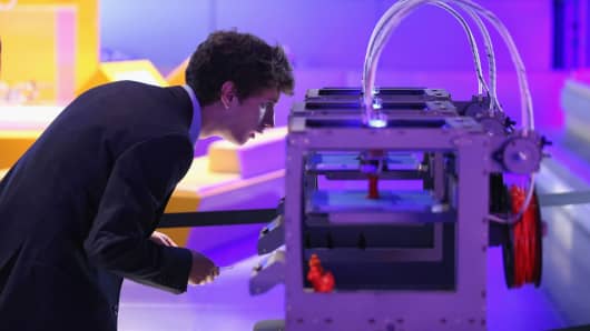 A technician checks on a 3D printer as it constructs a model human figure in the exhibition '3D: printing the future' in the Science Museum on October 8, 2013 in London, England.