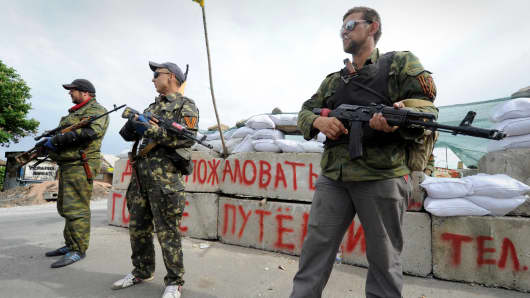 Pro-Russian armed militants stand guard at a barricade which faces a position manned by Ukrainian army soldiers near the eastern Ukrainian city of Slavyansk, Donetsk region, on May 23, 2014.