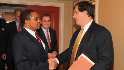 Bruce Wrobel (right) shakes hands with Tanzanian President Jakaya Kikwete (left) in September 2011 as members of the Blackstone Group and Sithe Global team look on.