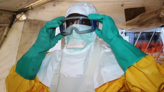 A picture taken on June 28, 2014 shows a member of Doctors Without Borders (MSF) putting on protective gear at the isolation ward of the Donka Hospital in Conakry, where people infected with the Ebola virus are being treated.