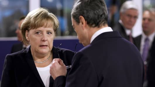German Chancellor Angela Merkel speaks with Mario Draghi, president of the European Central Bank (ECB).