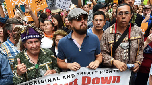 Actor Leonardo DiCaprio, center, walks down 6th Avenue during the People's Climate March on September 21, 2014, in New York.