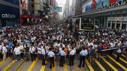 Anti-Occupy Central protesters stand behind a police cordon on Nathan Road at Hong Kong's Mongkok shopping district October 3, 2014.