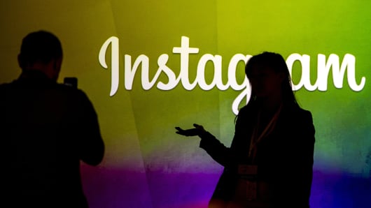 Les gens se découpent contre le logo Instagram au siège de Facebook à Menlo Park, en Californie.