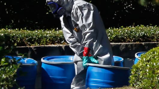 A hazmat worker removes a barrel from The Village Bend East apartment where a second healthcare worker who has tested positive for the Ebola virus resides.