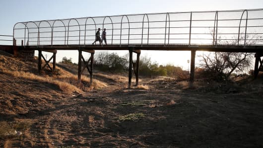 A footbridge spans a dry river bed in Porterville, Calif.