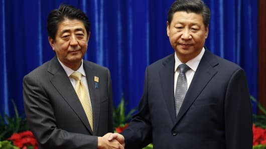 China's President Xi Jinping shakes hands with Japan's Prime Minister Shinzo Abe in Nov 10, 2014 during their meeting at the Great Hall of the People, on the sidelines of the Asia Pacific Economic Cooperation.