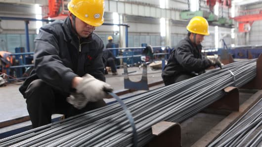 Two employees tie up steel bars at a steel-making plant in Ganyu, China.