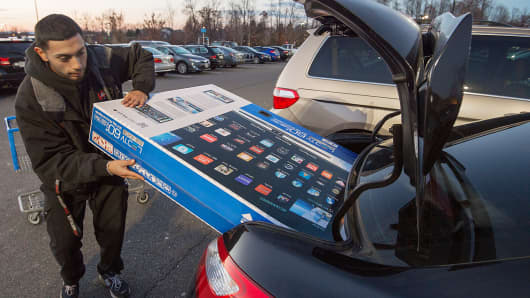 Umer Gonzalez loads his Samsung big screen TV in the trunk of his car after purchasing it at a Walmart in Fairfax, Va., Nov. 28, 2014.
