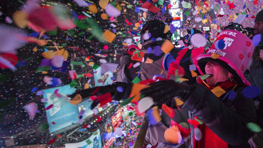 Revelers toss confetti over Times Square from a hotel balcony as the clock strikes midnight during New Year's Eve celebrations in New York, Jan. 1, 2015.
