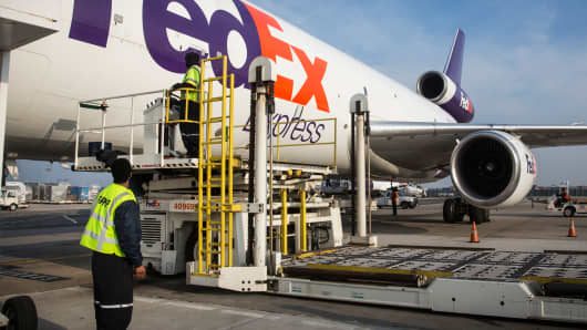 Workers prepare to offload an incoming FedEx plane in Newark, New Jersey.