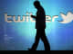 Silhouette of man against Twitter logo