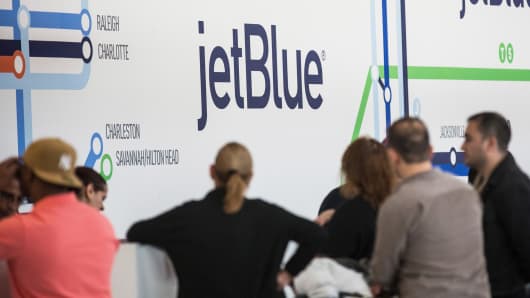 Customers check in at the JetBlue counter at John F. Kennedy Airport
