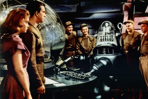 Anne Francis and Leslie Nielsen watch as the robot takes the controls of the spaceship in a scene from the film “Forbidden Planet.”