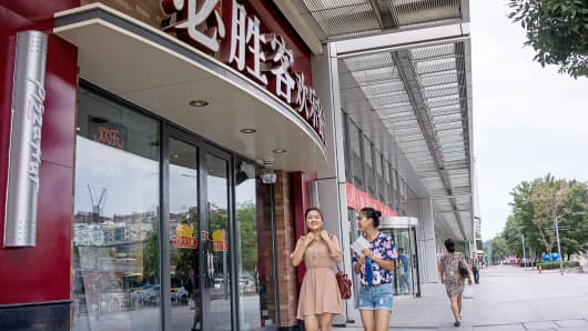 Pedestrians walk past a Pizza Hut restaurant in Beijing.