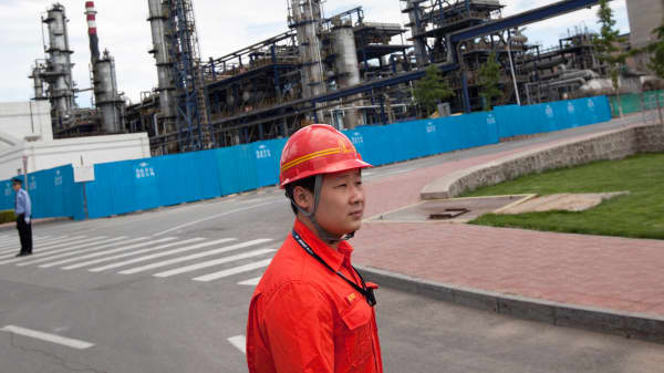 A worker at the China Petroleum & Chemical Corp. (Sinopec) Yanshan refinery escorts journalists in Beijing.