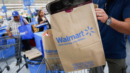 A customer puts a bag of purchases into a shopping cart at a Walmart Store in Los Angeles.