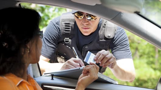 Woman receiving speeding ticket from police officer