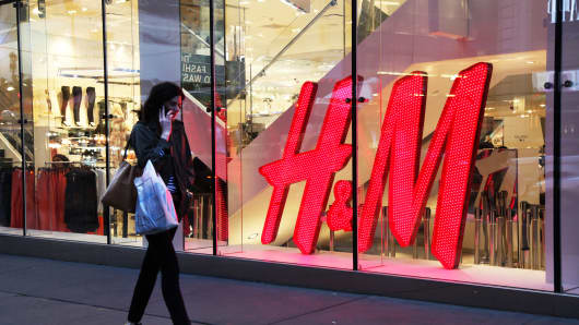 A woman walks past an H&M store in New York