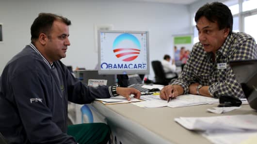 A customer speaks with an insurance agent as he signs up for Affordable Care Act in Miami.