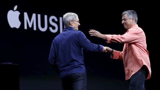 Apple CEO Tim Cook, left, greets senior vice president of internet services and software Eddy Cue.