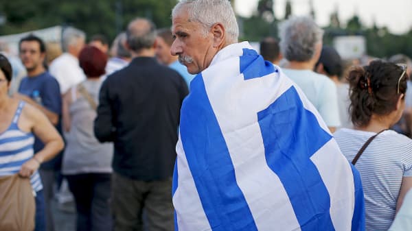 A man wears a Greek flag during a pro-government rally calling on Greece's European and International Monetary creditors to soften their stance in the cash-for-reforms talks in Athens, Greece, June 17, 2015.
