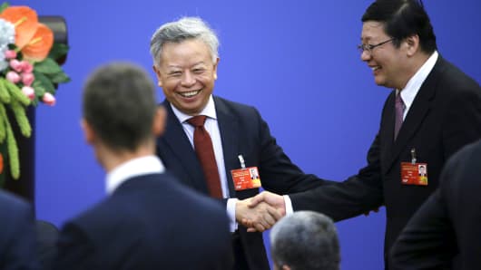 Jin Liqun, left, current secretary general of the Multilateral Interim Secretariat of Asian Infrastructure Investment Bank, shakes hands with China's Finance Minister Lou Jiwei ahead of a signing ceremony of articles of agreement of the AIIB, at the Great Hall of the People in Beijing, June 29, 2