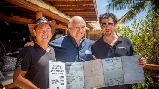 “The Mystery of Capital” author Hernando DeSoto (center) displaying layers of land titles that can be consolidated into a few lines of code on the block chain.  With Bill Tai (left) and George Kikvadze, vice chairman of BitFury (right).
