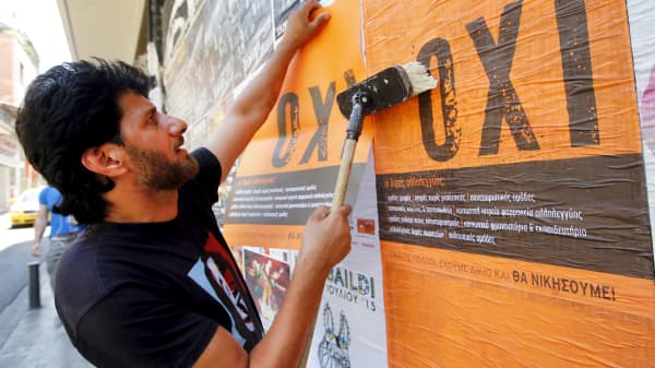 A man puts up posters with the word "No" in Greek in Athens, July 1, 2015.