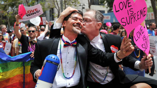 Stuart Gaffney (L) and John Lewis, plaintiffs in the 2008 Defense of Marriage Act (DOMA) case, celebrate while traveling along Market Street during the annual Gay Pride Parade in San Francisco, California on June 28, 2015.