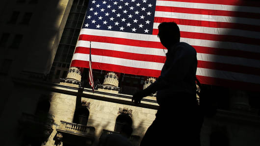 A pedestrian passes in front of the New York Stock Exchange.
