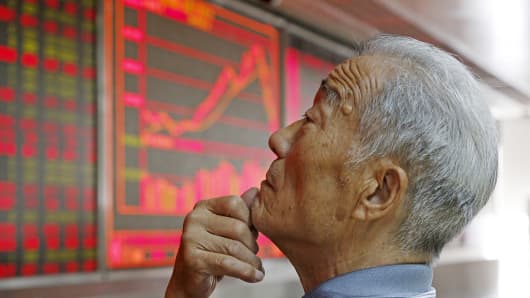 An investor watches an electronic board showing stock information at a brokerage office in Beijing, July 9, 2015. China shares rebounded sharply Thursday, with the Shanghai composite index posting its biggest percentage gain in six years.