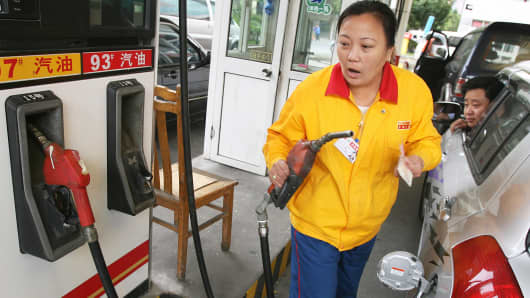 A gas station attendant at pumps gasoline at a PetroChina outlet in Shanghai.
