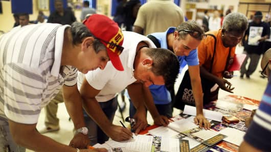 People fill out a form for job opportunities during the Miami Worldcenter construction job fair.