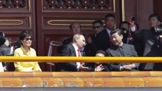 BEIJING, CHINA - SEPTEMBER 03: Russian President Vladimir Putin (C) chats with China's President Xi Jinping (R) next to South Korean President Park Geun-hye on Tiananmen Gate during the military parade marking the 70th anniversary of the end of World War Two on September 3, 2015 in Beijing, China. China is marking the 70th anniversary of the end of World War II and its role in defeating Japan with a new national holiday and a military parade in Beijing.