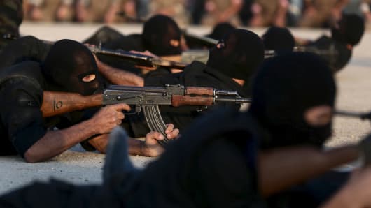 Rebel fighters aim their weapons as they demonstrate their skills during a military display as part of a graduation ceremony at a camp in eastern al-Ghouta, near Damascus, Syria July 12, 2015. The newly graduated rebel fighters, who went through military training, will join the the Free Syrian Army's Al Rahman legion.