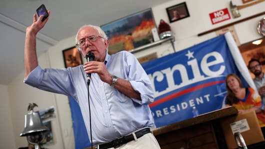 U.S. Sen. Bernie Sanders (I-VT) holds up his mobile phone while while speaking August 16, 2015 in Clinton, Iowa.